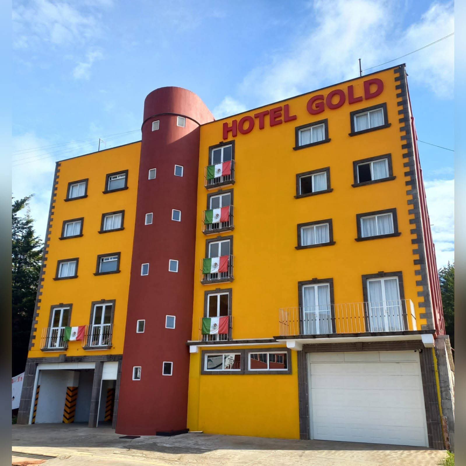 Fachada frontal del Hotel Gold con banderas de México